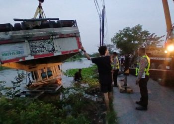 Quick Respon Satlantas Polres Lamongan dan Polsek Karangbinangun Evakuasi Truk Terguling ke Sungai, Perahu Warga Rusak